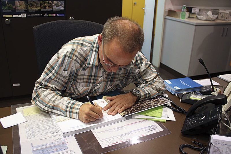 Marcel Michel beim Signieren seines Buchs an der Vernissage im Naturmuseum Chur.